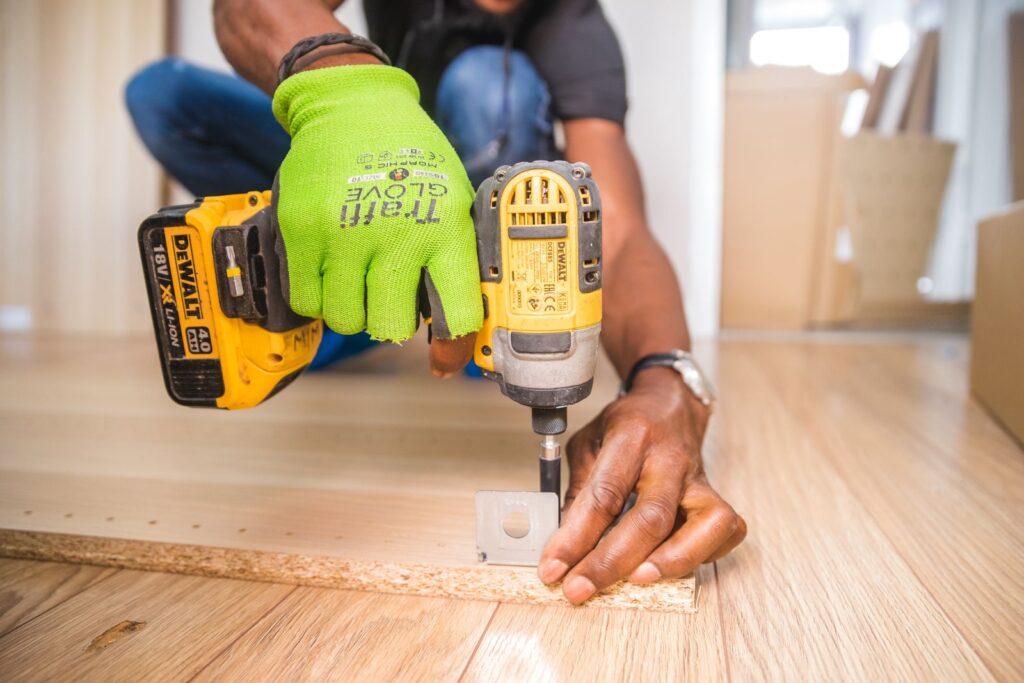 our-mission Installer using a drill while fitting laminate flooring